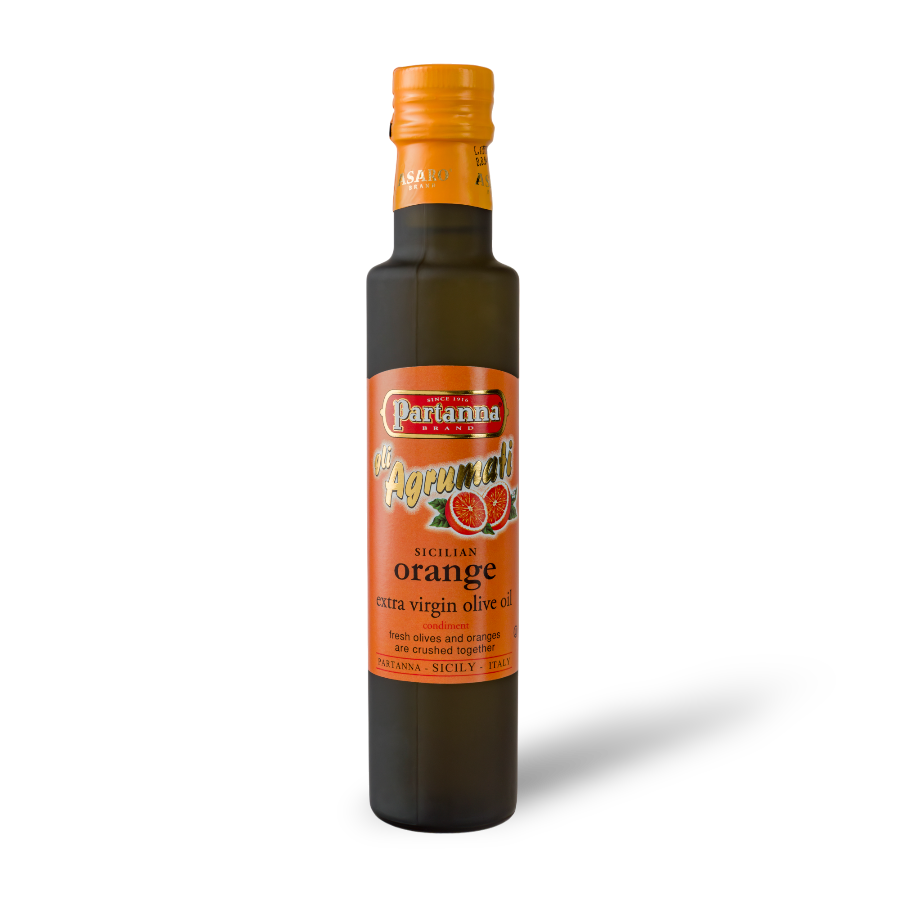 A dark glass bottle of Partanna Sicilian Orange Extra Virgin Olive Oil with a bright orange cap and a label that showcases the product name and orange imagery.