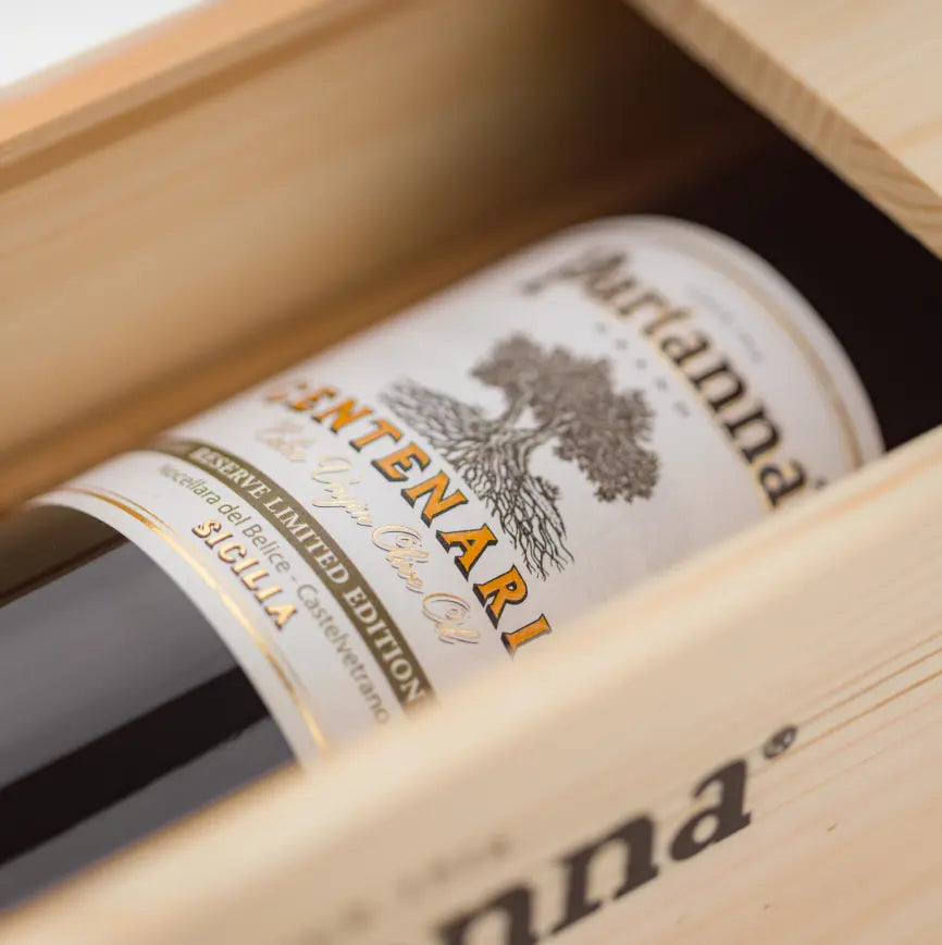 Partanna olive oil bottle with wooden box on a white background