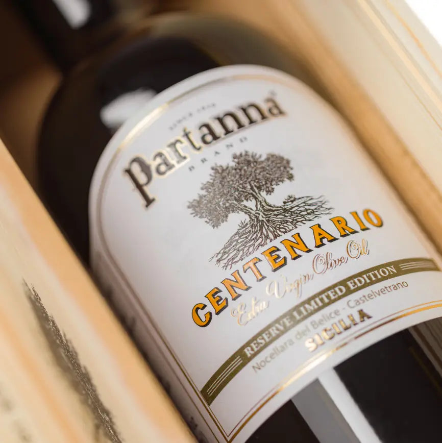 Partanna olive oil bottle with wooden box on a white background